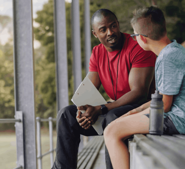 male coach talking to young boy