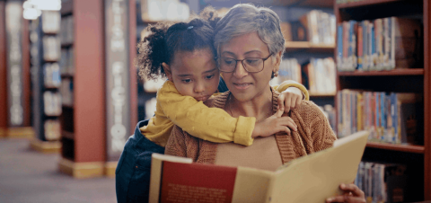 older woman reading to a young child in a library